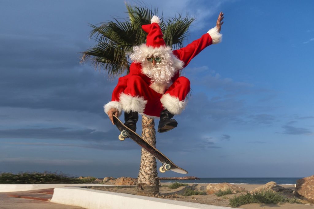 Mann Weihnachtsmannkostüm Skateboarding Weihnachtszeit lizenzfrei foto